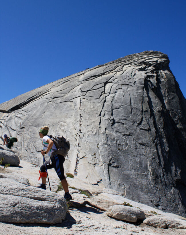 Stephanie Aikin hiking up a rock.