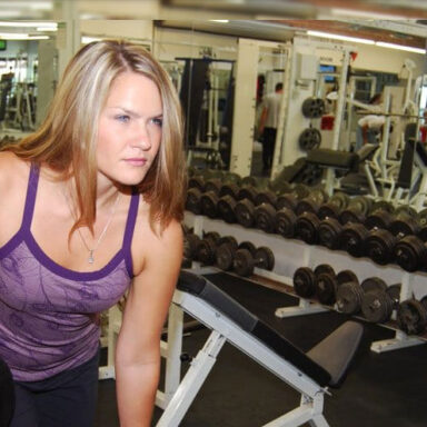 Stephanie Aikin lifting weights in her gym.