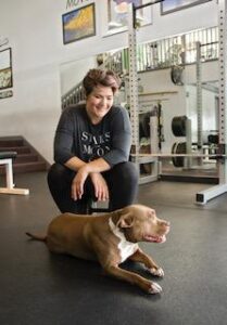 Stephanie Aikin with her dog on the floor.