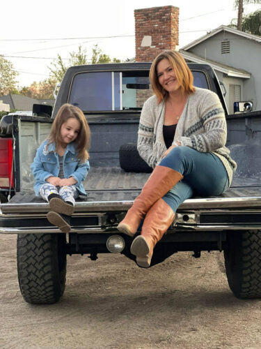 Stephanie Aikin sitting in the back of a pick up truck with her niece.