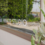 Move Your Mountain outside window with "Unique Private Studio" on the window.