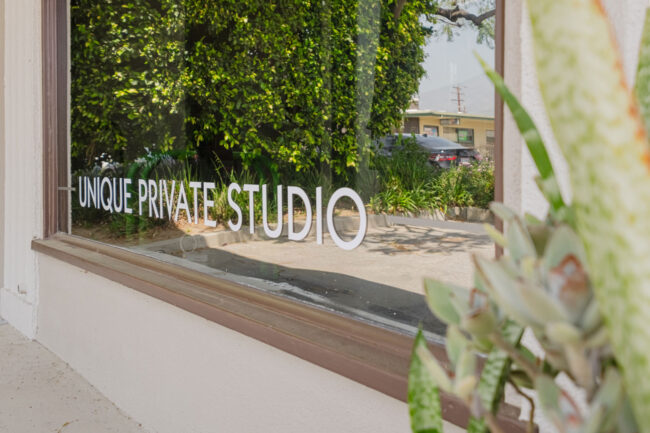 Move Your Mountain outside window with "Unique Private Studio" on the window.